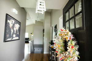 Hall with dark wood-style floors and vaulted ceiling