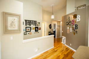 Hallway featuring light wood finished floors and a high ceiling