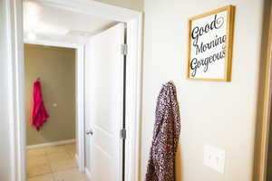 Corridor featuring light tile patterned floors and baseboards