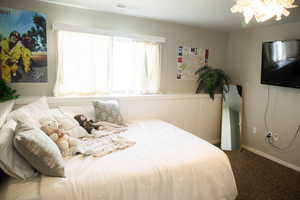 Bedroom with carpet floors and a chandelier