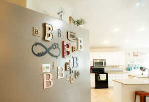 Kitchen with black electric range, white cabinetry, stainless steel microwave, recessed lighting, and light tile patterned flooring