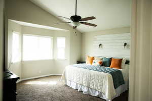 Carpeted bedroom with lofted ceiling and a ceiling fan
