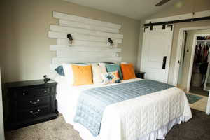 Carpeted bedroom featuring vaulted ceiling, ceiling fan, and a closet