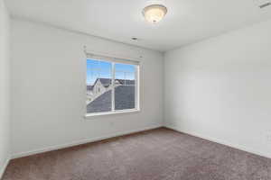 Spare room with baseboards and carpet flooring