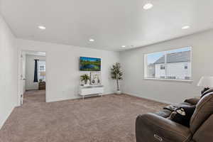 Sitting room featuring carpet floors, healthy amount of natural light, and recessed lighting