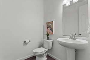 Bathroom featuring toilet and dark wood-style flooring
