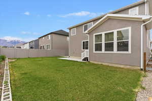 Back of property featuring stucco siding, a mountain view, and a patio