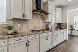 Kitchen featuring light stone counters, dark wood-style floors, white cabinets, and recessed lighting