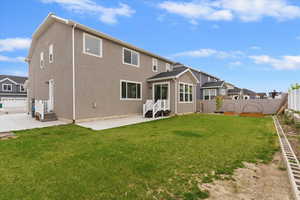 Rear view of property featuring entry steps, a fenced backyard, and stucco siding