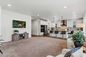 Living area featuring dark colored carpet and recessed lighting