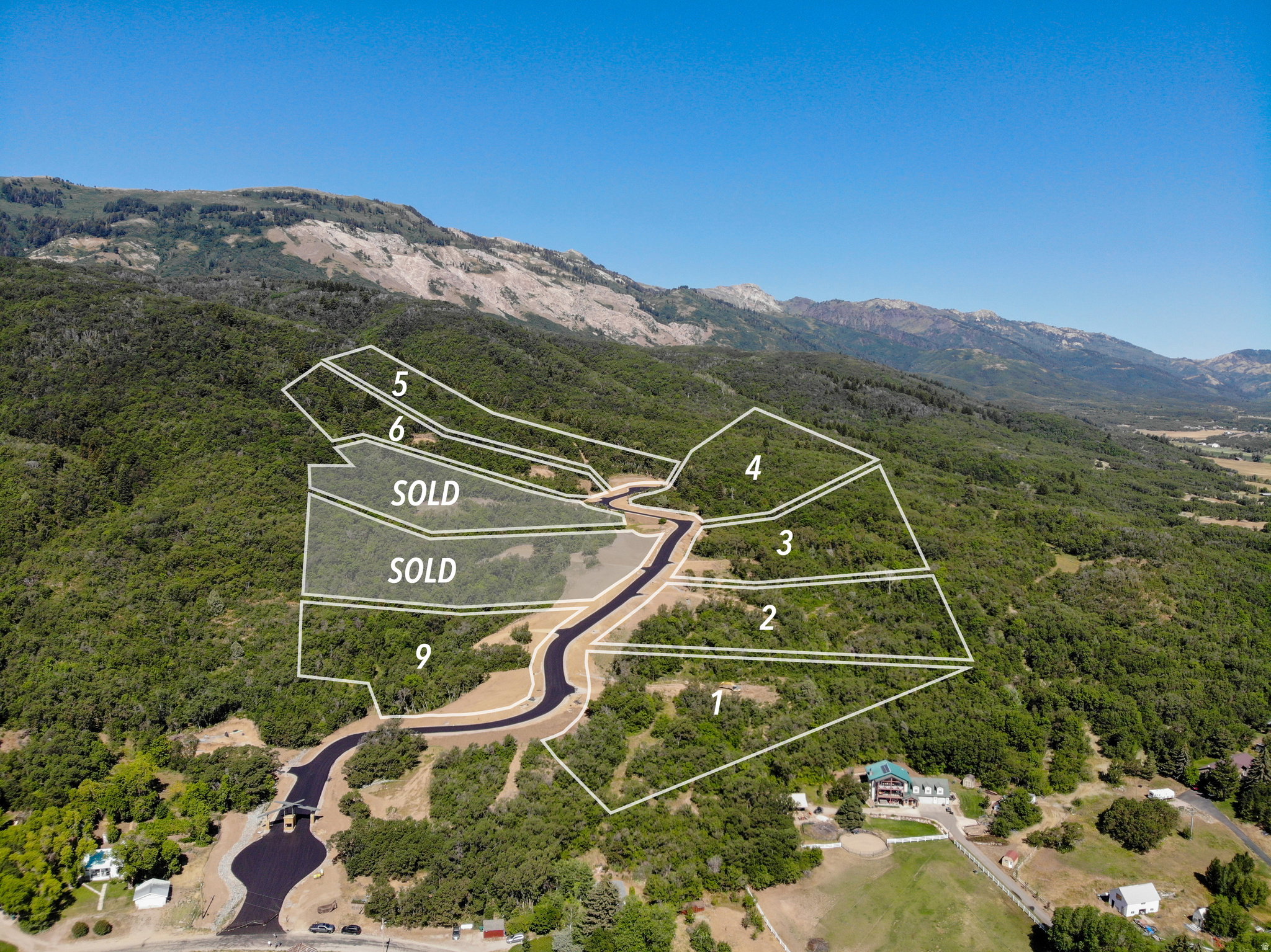 Aerial overview of property's location featuring property boundaries highlighted and a mountain backdrop
