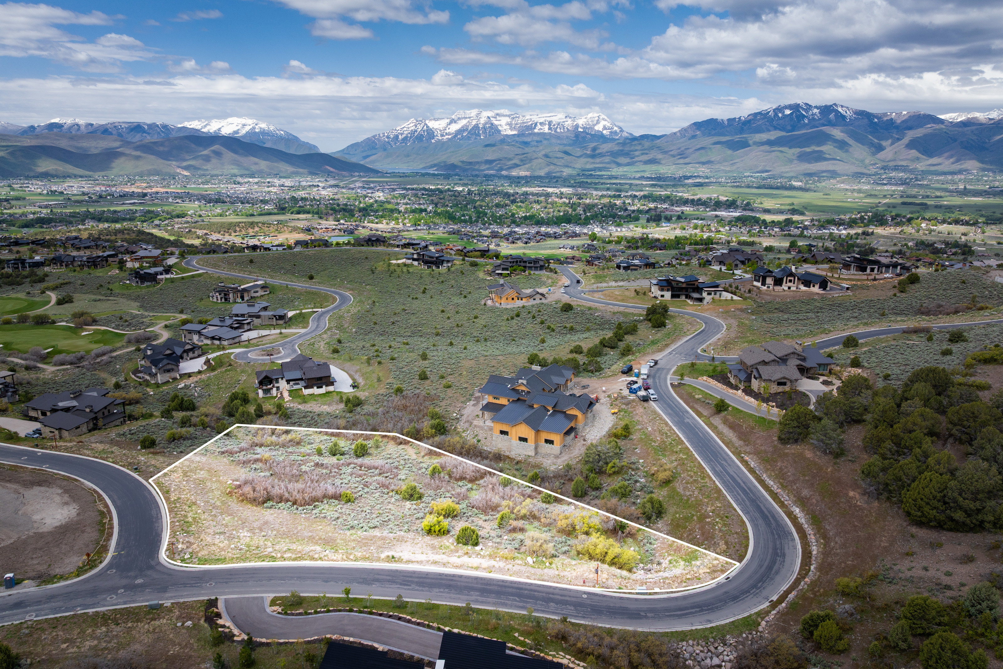 Aerial view of residential area featuring mountains and property boundaries highlighted