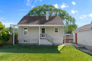 View of front of house with a chimney, roof with shingles, and a patio
