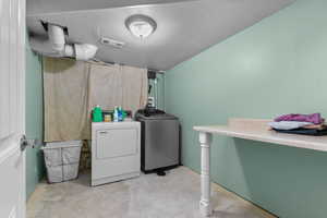 Laundry room with unfinished concrete flooring and independent washer and dryer