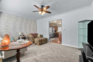 Living area with light carpet and a ceiling fan