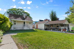 Back of property featuring a yard, a patio, and a chimney