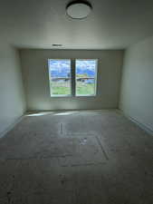 Spare room with baseboards and a textured ceiling