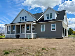 View of front of house featuring roof with shingles, a porch, board and batten siding, and a garage