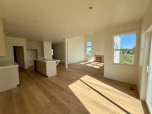Kitchen featuring open floor plan, light wood finished floors, an island with sink, a kitchen bar, and recessed lighting