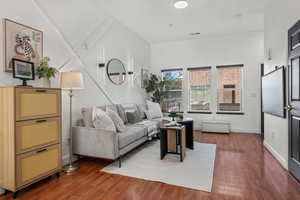 Living area with dark wood-style floors and baseboards