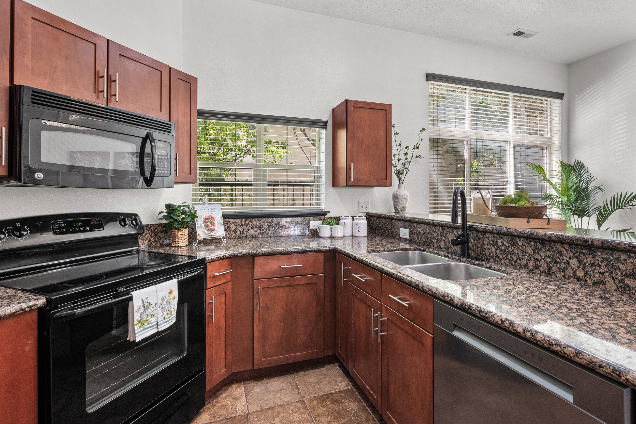 Kitchen featuring black appliances and dark stone counters