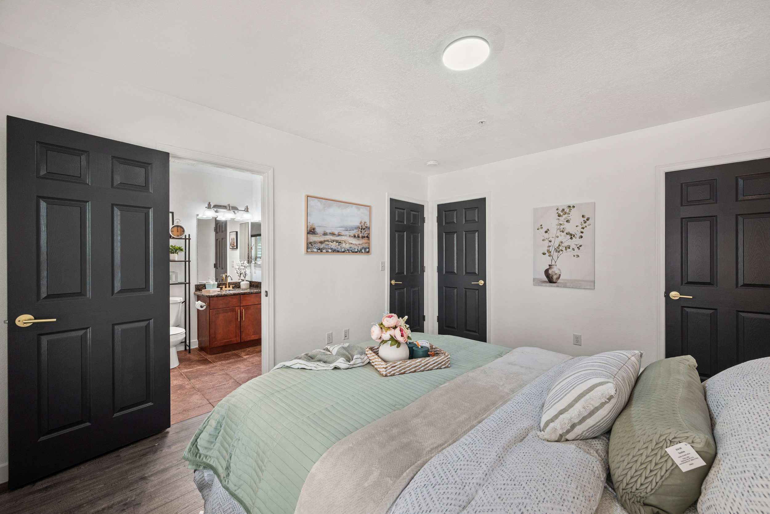 Bedroom featuring wood finished floors and connected bathroom
