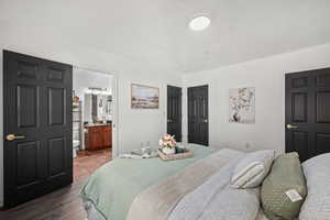Bedroom featuring wood finished floors and connected bathroom