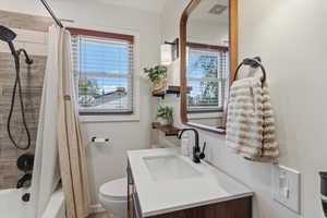 Full bath with plenty of natural light, vanity, and shower / bathtub combination with curtain