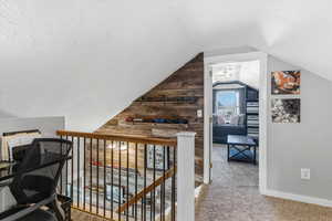 Hallway with light colored carpet and baseboards