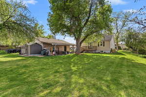 Rear view of property featuring a patio, a storage shed, and a wooden deck