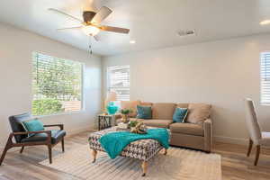 Living area featuring wood finished floors, a ceiling fan, healthy amount of natural light, recessed lighting, and a textured ceiling