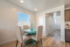 Dining area featuring light wood finished floors, healthy amount of natural light, and recessed lighting