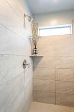 Full bath featuring tiled shower