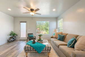 Living area with wood finished floors, a ceiling fan, and recessed lighting