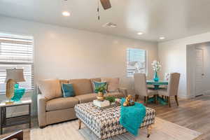 Living room featuring wood finished floors, ceiling fan, recessed lighting, and a textured ceiling