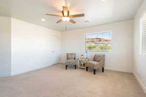 Living area featuring light colored carpet, ceiling fan, and recessed lighting