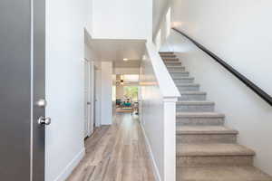 Stairway with wood finished floors and recessed lighting