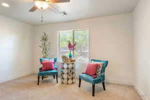 Sitting room featuring a ceiling fan and light colored carpet