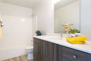 Full bath featuring vanity, light wood-style floors, and bathing tub / shower combination