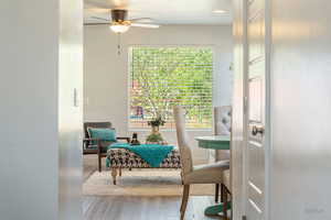 Sitting room with light wood finished floors, a textured ceiling, and ceiling fan