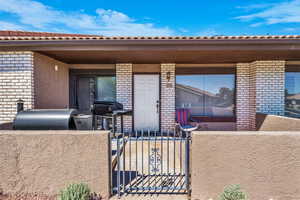 Property entrance with a gate and brick siding