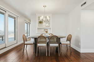 Dining room featuring dark wood-style floors and suspended lighting