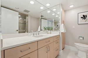 Full bathroom featuring vanity, light tile patterned floors, a tile shower, and recessed lighting