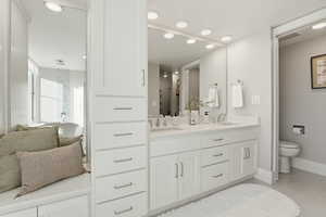 Full bath featuring double vanity, recessed lighting, and light tile patterned floors