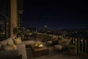 Patio at twilight with outdoor lounge area, a patio area, and a view of city lights