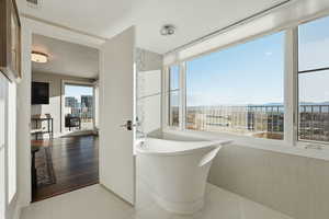 Bathroom with a freestanding bath and light tile patterned floors