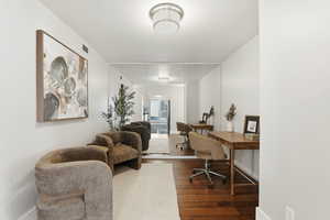 Office area with dark wood-style flooring and baseboards