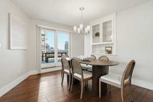 Dining space with dark wood-type flooring, suspended lighting, and a view of skyline