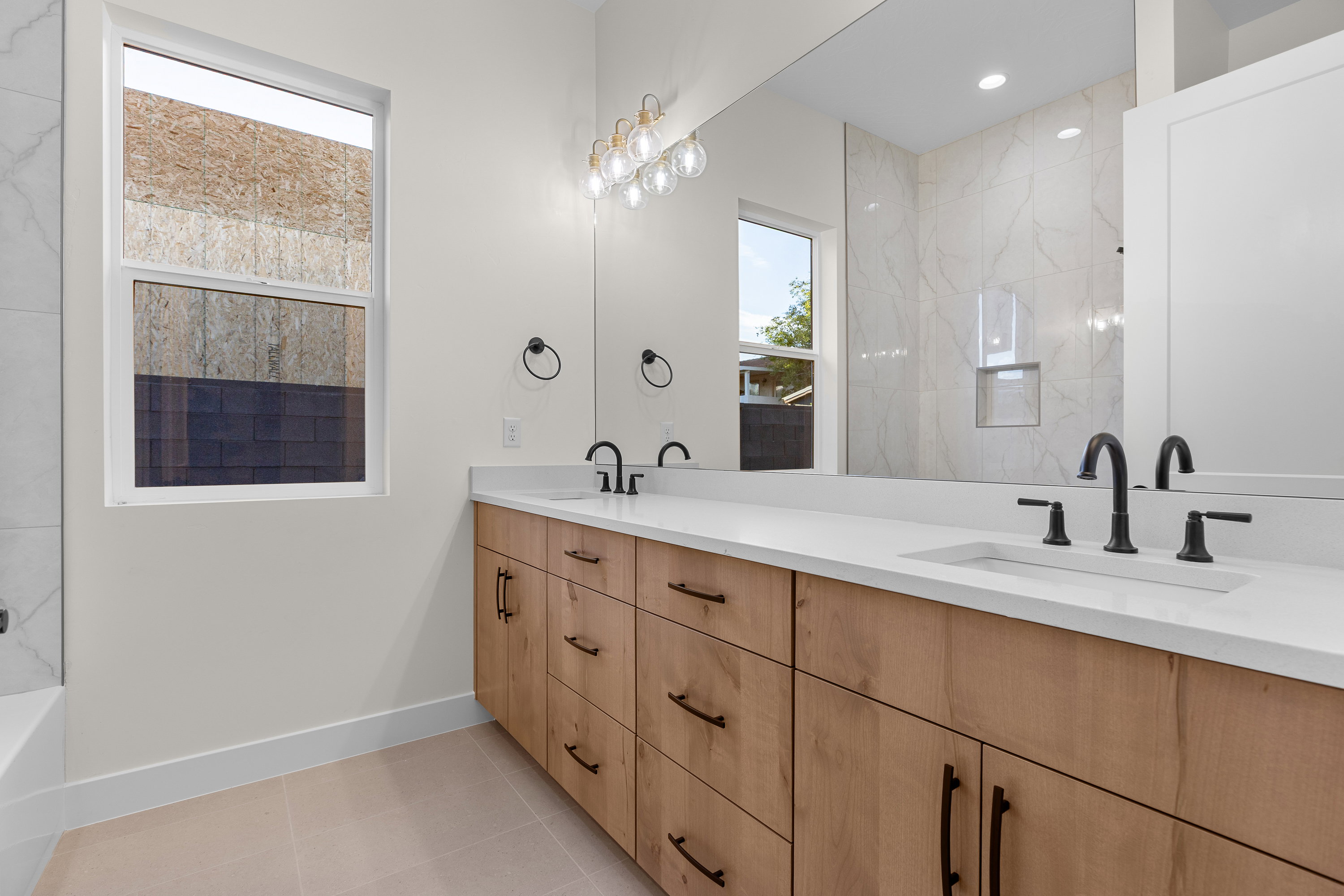 Bathroom featuring double vanity, light tile patterned floors, a shower, and a tub