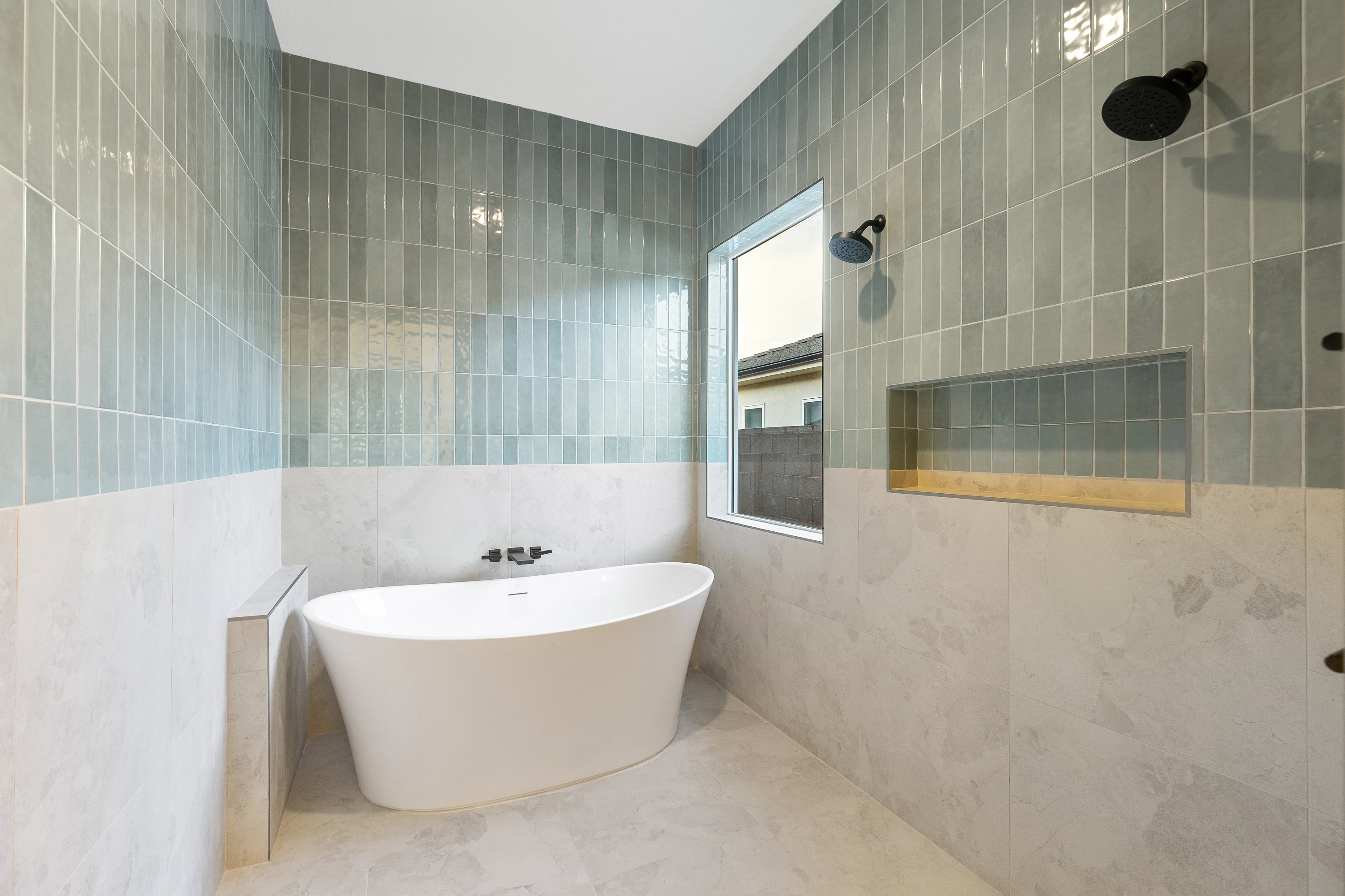 Full bath with tile walls, a freestanding bath, and a tile shower